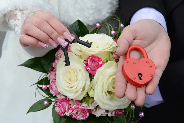 Mano de pareja sosteniendo la cerradura de boda —  Fotos de Stock