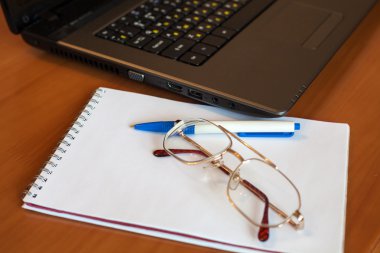 gözlük ile defter ve laptop kalemin