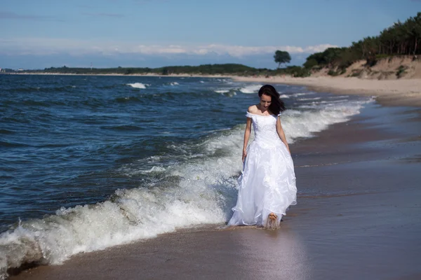 Giovane ragazza che cammina lungo la riva del mare — Foto Stock