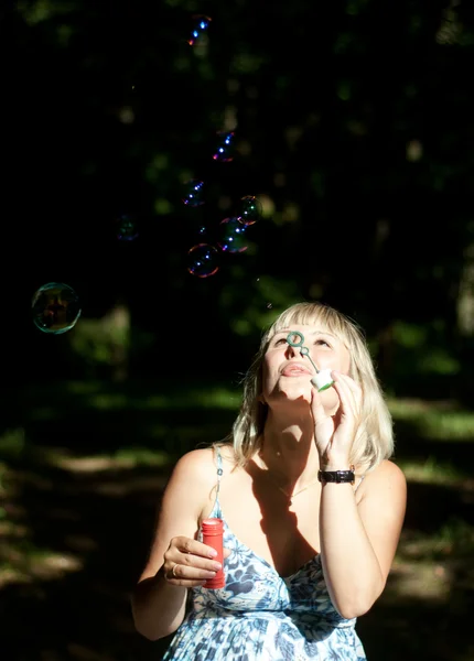 Young pregnant woman blowing soap bubbles — Stock Photo, Image