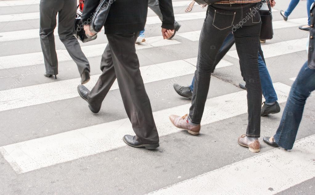 legs of pedestrians in a crosswalk