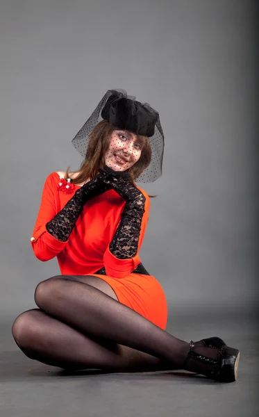 Joven con un vestido rojo y un sombrero negro — Foto de Stock