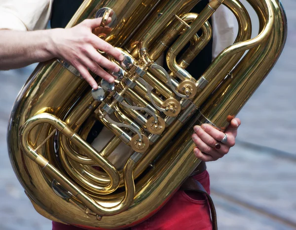 Handen van een muzikant met een helicon — Stockfoto