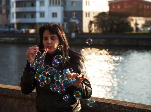 Young beautiful woman blows bubbles — Stock Photo, Image