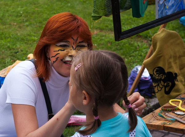 Kadın boyama maskesi kızın yüzündeki boyalar — Stok fotoğraf