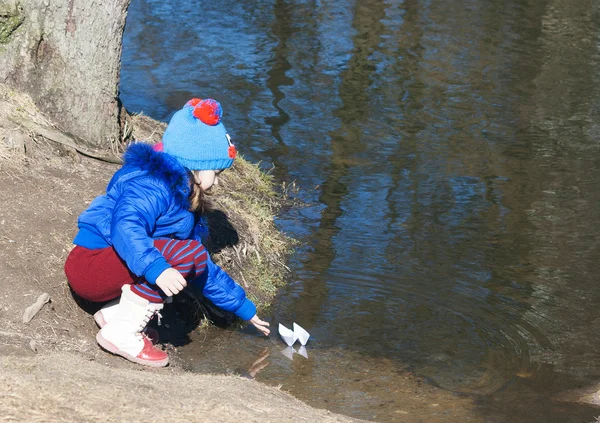 Klein meisje spelen met papier boot — Stockfoto