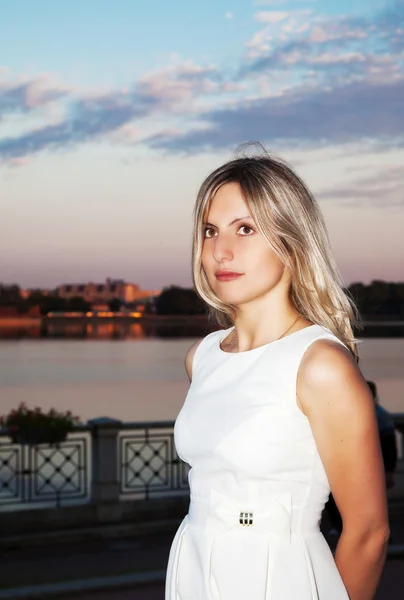 Retrato de una hermosa joven con un vestido blanco cerca de la — Foto de Stock