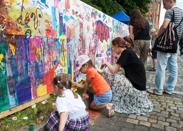 Kinder malen an einer Mauer im Stadtpark — Stockfoto