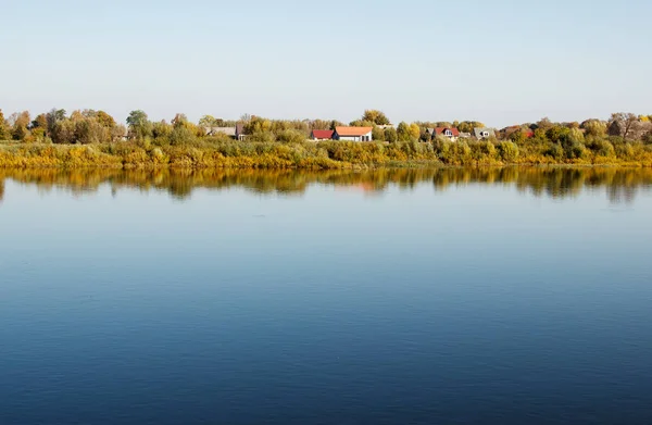 秋の晴れた日に川のそばの小さな町 — ストック写真