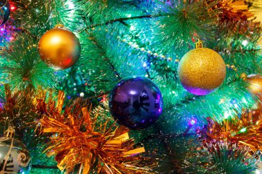Parlak renkli dekorasyon topları Noel ağacının içinde yakın plan.