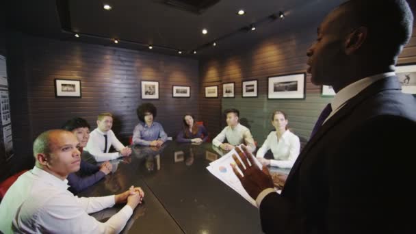 Business presentation with mature, experienced manager addressing his young team — Stock Video