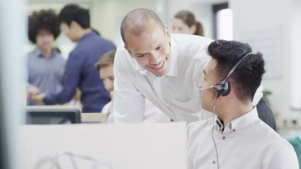 Glada unga kunden operatörer på jobbet i en upptagen callcenter — Stockvideo