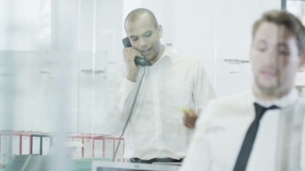 Selbstbewusster junger Geschäftsmann am Telefon in einem modernen Büro — Stockvideo