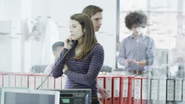 Atractiva mujer de negocios vestida casualmente por teléfono en una oficina moderna — Vídeos de Stock