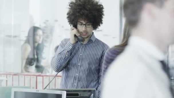 Casualmente vestido joven profesional en el teléfono en una oficina moderna — Vídeos de Stock