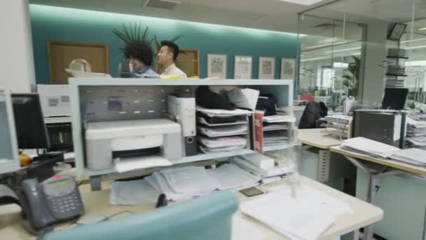 Zwei junge Geschäftsleute reden miteinander, während sie durch das Büro gehen — Stockvideo