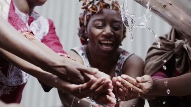 Flusso di acqua dolce e le mani di persone provenienti da una comunità povera — Video Stock