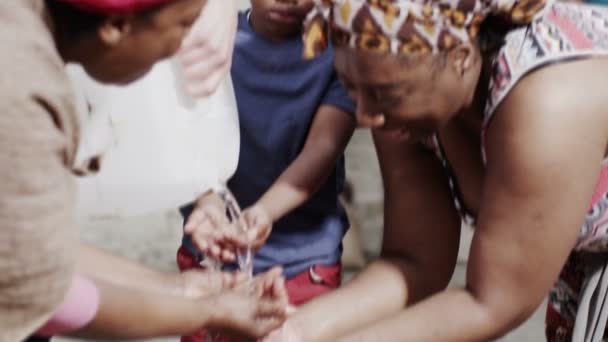 Strumień wody słodkiej i ręce osób z biednych społeczności — Wideo stockowe