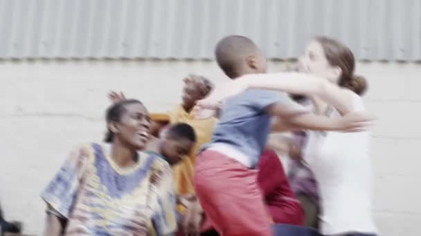 Gelukkig jongetje wordt uitgevoerd om te omhelzen een medische werknemer van een organisatie van de liefdadigheid — Stockvideo