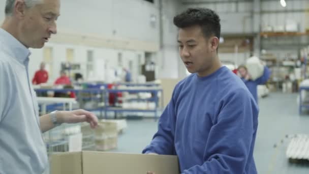 Glada fabrik eller lager arbetare med instruktion från förman — Stockvideo