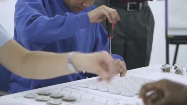 Travailleurs de sexe masculin issus d'une ethnie mixte dans une usine d'assemblage de raccords électriques — Video