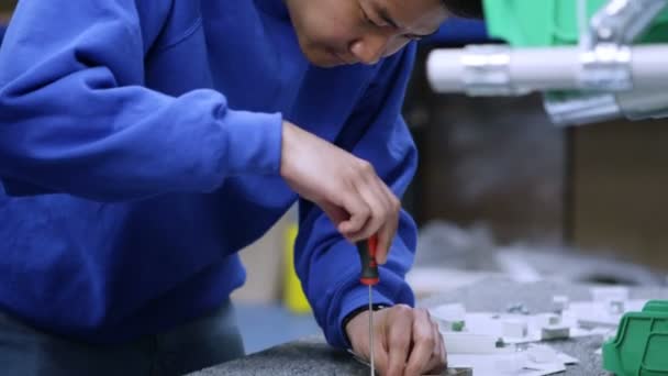 Joven trabajador de la fábrica asiática concentrándose en su trabajo — Vídeos de Stock