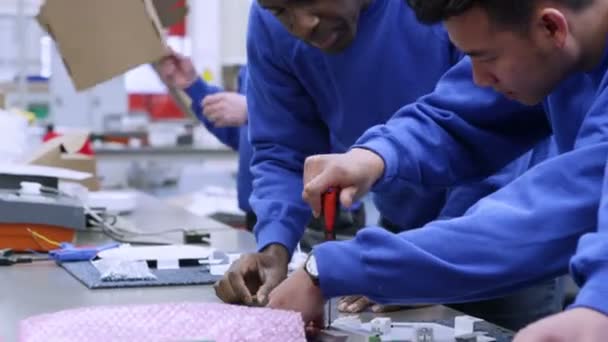 Personal masculino de la fábrica de etnia mixta trabajando juntos en una línea de montaje — Vídeos de Stock