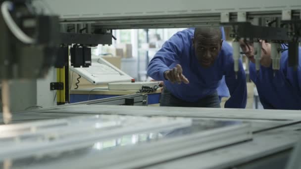 Male machine operators in a factory checking the process — Stock Video