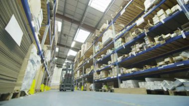 raf sıraları arasında bir fabrika veya depo sürüş forklift sürücüsü