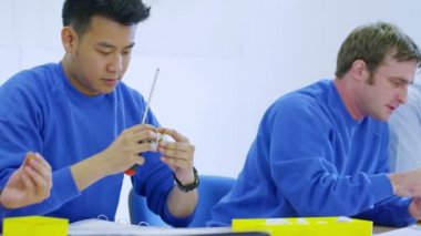 ekip erkek işçiler fabrikada elektrik armatürleri montajı