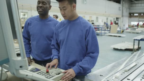 Cheerful factory or warehouse workers checking the machinery — Stock Video