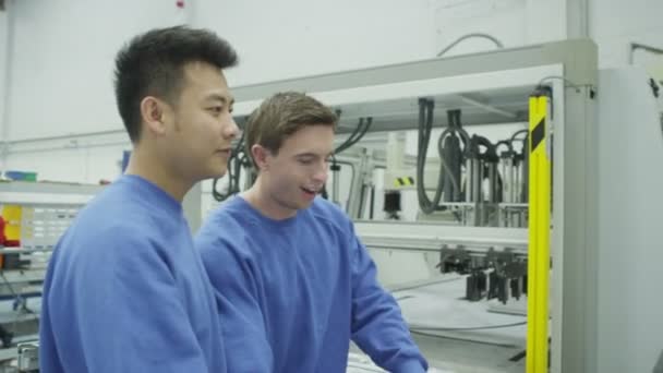 Cheerful factory or warehouse workers checking the machinery — Stock Video