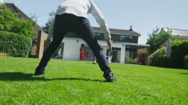 schattige jonge jongen sporten met zijn vader, in de tuin op een zomerdag