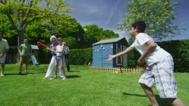 Aile ve arkadaşlar birçok nesildir oynarken spor bahçede güneşli bir günde