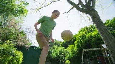 aktif genç çocuk futbol hünerlerini güneşli bir günde dışarıda pratik