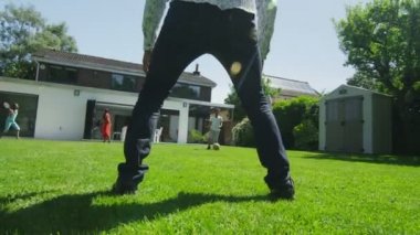 schattige jonge jongen sporten met zijn vader, in de tuin op een zomerdag