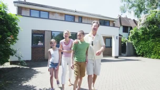 Retrato da família caucasiana feliz na frente de sua casa em um dia ensolarado — Vídeo de Stock