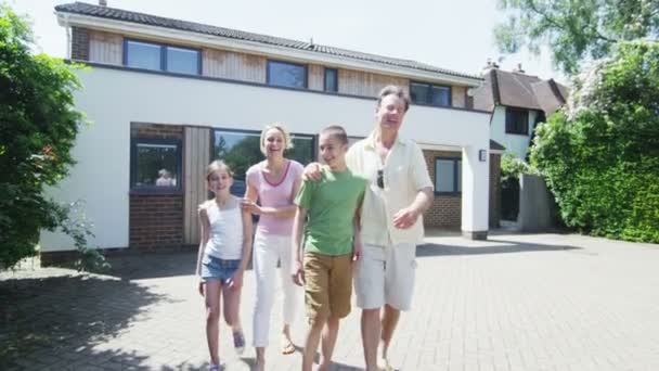 Portrait of happy caucasian family in front of their home on a sunny day — Stock Video