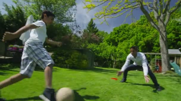 Lindo joven jugando deportes con su padre, en el jardín en un día de verano — Vídeo de stock