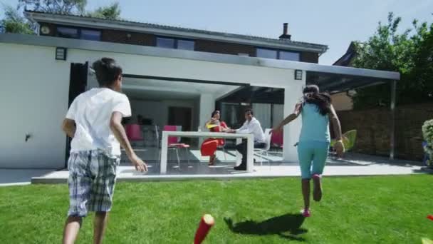 Lycklig asiatiska familj dricka kalla drycker utanför moderna hem en sommardag — Stockvideo