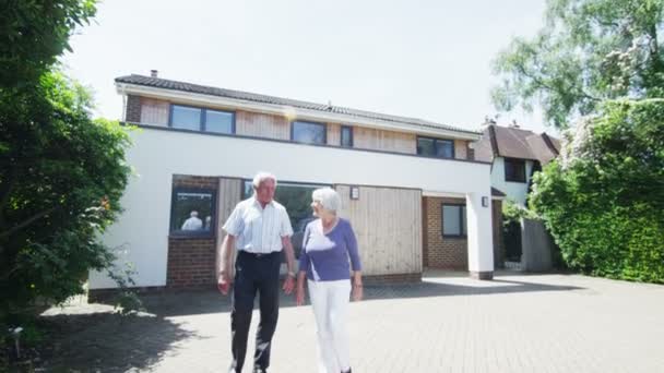 Romántica pareja de ancianos comparten un beso en frente de su casa en un día soleado — Vídeos de Stock