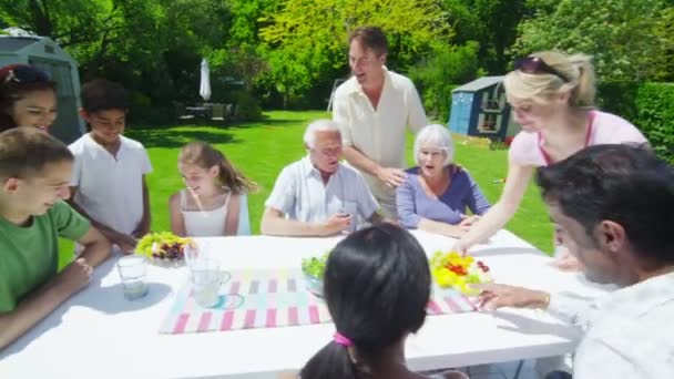 Família e amigos de muitas gerações desfrutar de almoço no jardim em um dia de verão — Vídeo de Stock