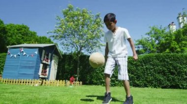 schattige jonge jongen sporten met zijn vader, in de tuin op een zomerdag