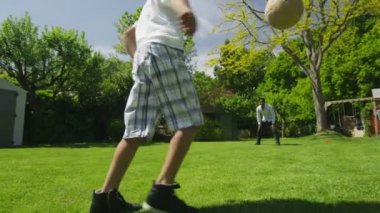 schattige jonge jongen sporten met zijn vader, in de tuin op een zomerdag