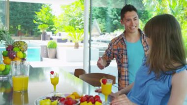 mutlu genç bir çift sağlıklı suyu içme modern ev mutfağında içki içer.