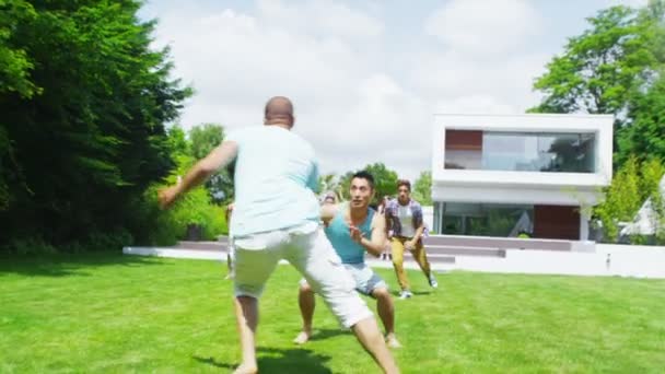 Grupo atlético de amigos varones juegan al fútbol en el jardín de la casa contemporánea — Vídeo de stock