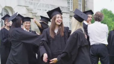 Öğrenci arkadaşlar birbirlerini mezuniyet gününde sarılma
