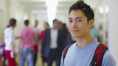 Koridorda duran erkek Asya öğrenci