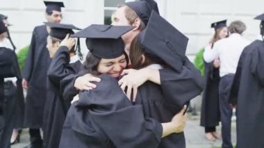 Öğrenci arkadaşlar birbirlerini mezuniyet gününde sarılma