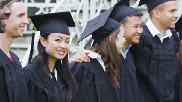 Estudiante amigos en el día de la graduación de pie al aire libre — Vídeo de stock